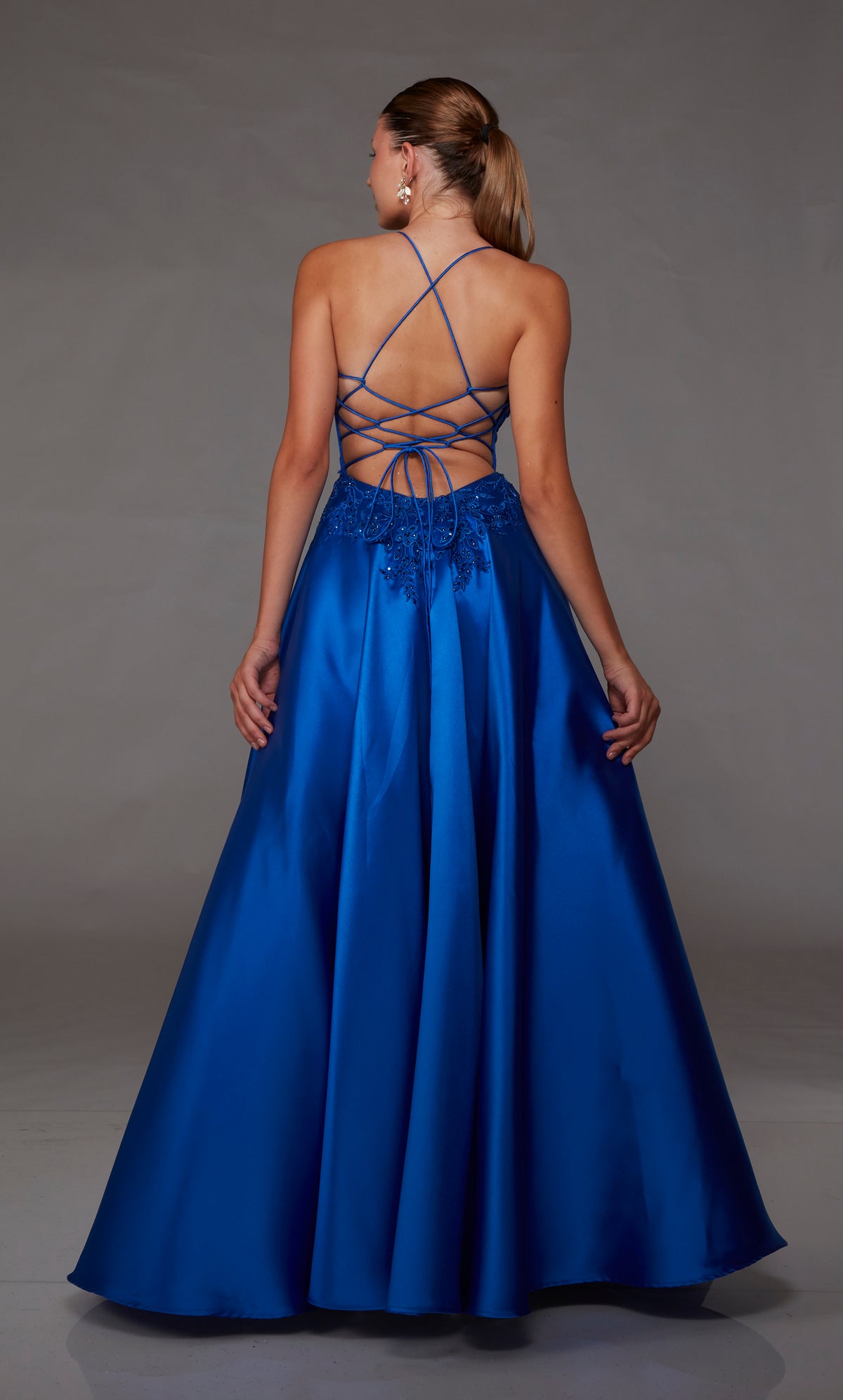 Royal blue ball gown spotlighting an plunging corset bodice with beaded floral lace appliques and an strappy lace-up back for an enchanting and stylish look.